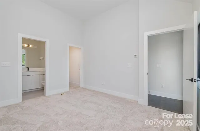a view of an empty room and closet and a bathroom