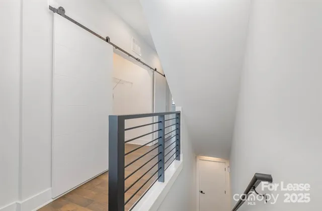 a view of a hallway with wooden floor and entryway