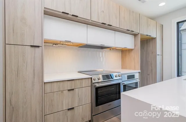 a kitchen with stainless steel appliances a refrigerator and a stove top oven