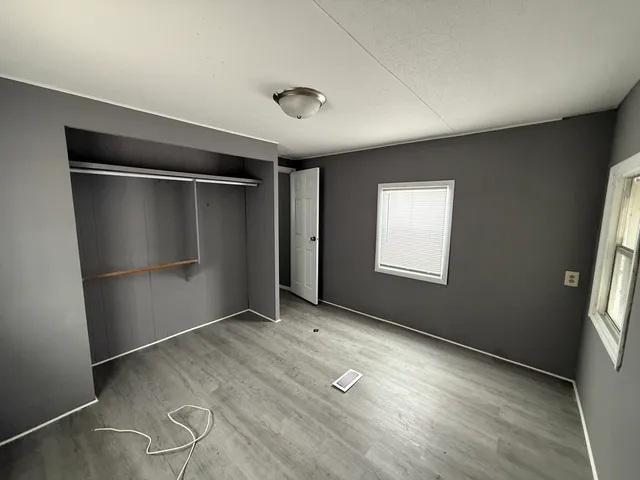 an empty room with windows and closet