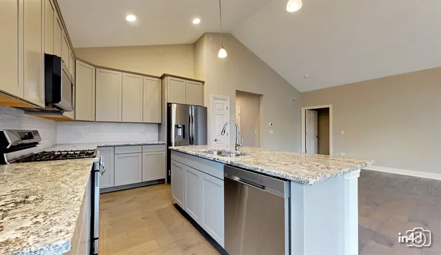 a kitchen with stainless steel appliances granite countertop a sink stove and refrigerator