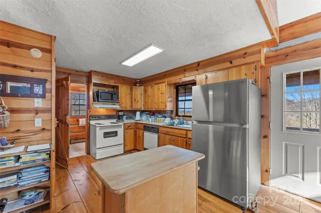 a kitchen with stainless steel appliances granite countertop a sink and cabinets with wooden floor