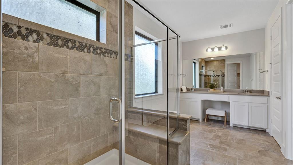 602 Winners Circle Rowlett, TX 75088 - Photo 14 of 28 Full bathroom with double vanity, a shower stall, and light stone finish floors