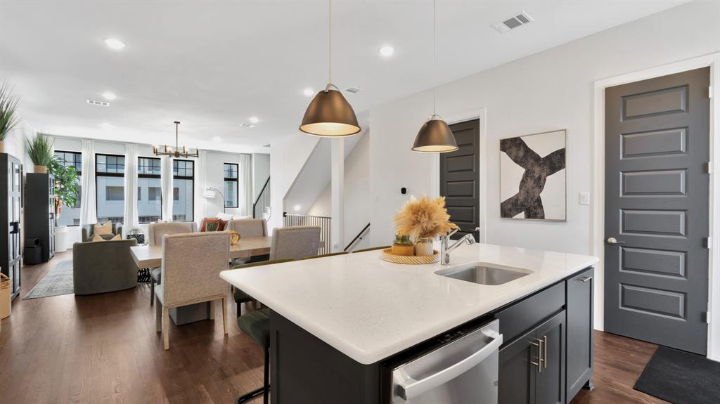 602 Winners Circle Rowlett, TX 75088 - Photo 27 of 28 Kitchen featuring a center island with sink, open floor plan, hanging light fixtures, recessed lighting, and dark wood-style flooring