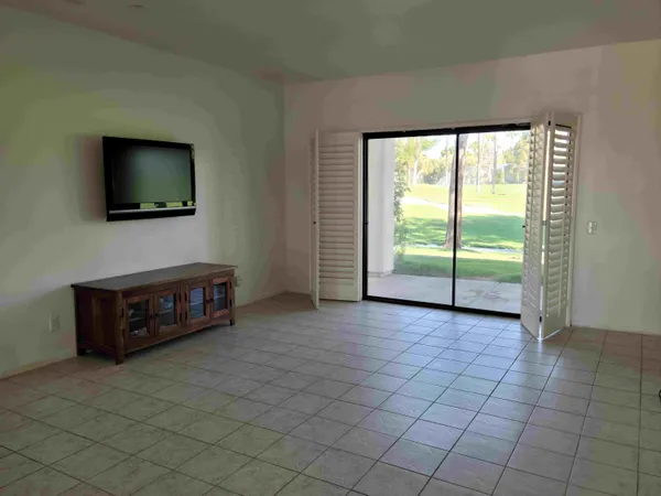 a living room with a flat screen tv and floor to ceiling window