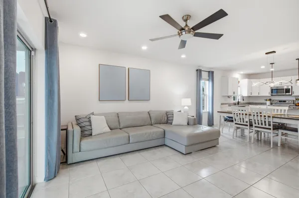 a living room with furniture and a view of kitchen