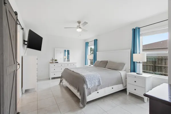 a spacious bedroom with a bed and a flat screen tv