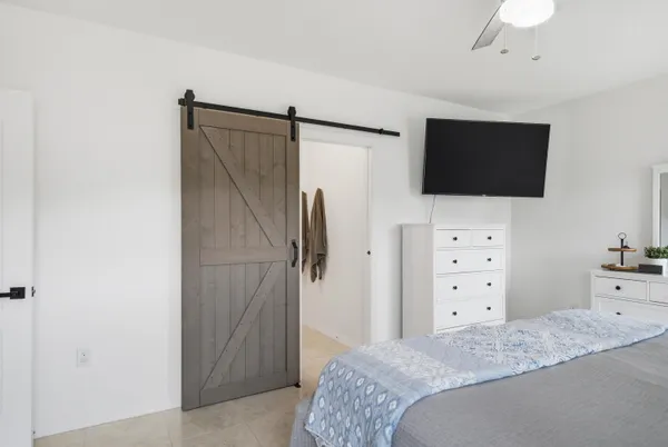 a bedroom with a bed and a flat screen tv