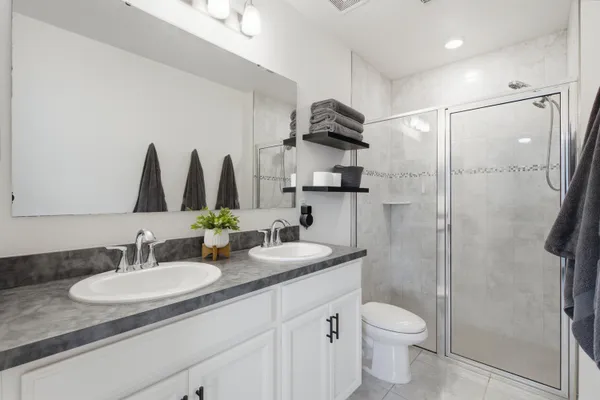 a bathroom with a granite countertop sink a toilet and a mirror