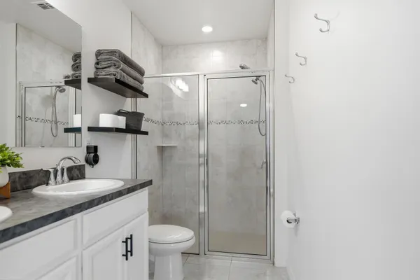 a bathroom with a sink a toilet and shower
