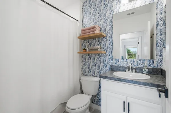 a bathroom with a granite countertop toilet sink and mirror