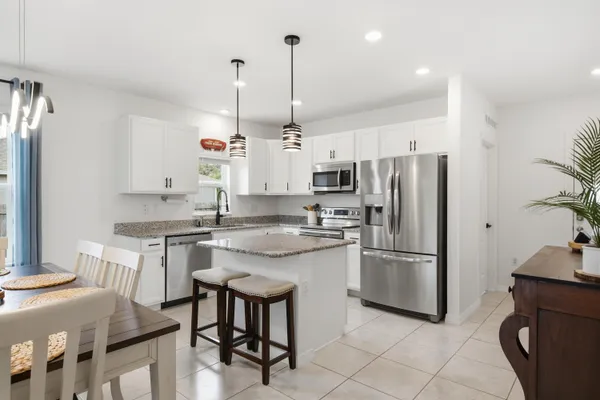 a kitchen with stainless steel appliances granite countertop a sink a stove a refrigerator and island