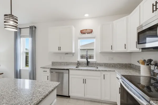 a kitchen with stainless steel appliances granite countertop a sink stove and cabinets