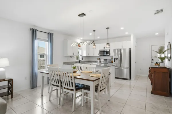 a kitchen with stainless steel appliances kitchen island granite countertop a table and chairs in it