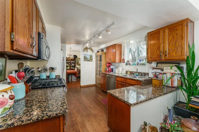 a kitchen with stainless steel appliances granite countertop a refrigerator a stove top oven a sink and dishwasher