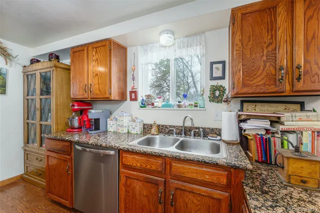a kitchen with kitchen island granite countertop a sink dishwasher stove and cabinets