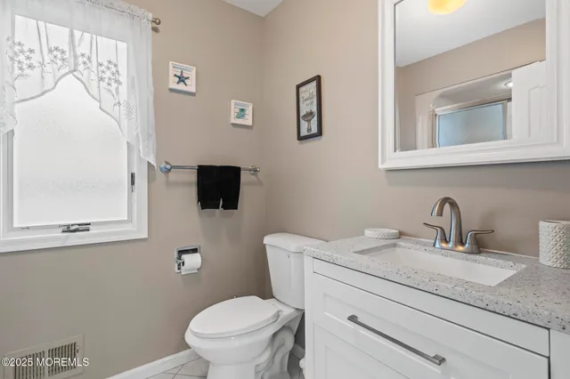 a bathroom with a granite countertop sink mirror and shower