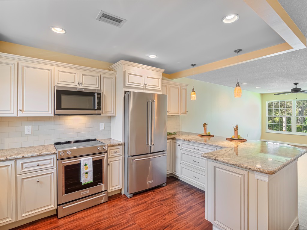 a kitchen with granite countertop a refrigerator stove and sink