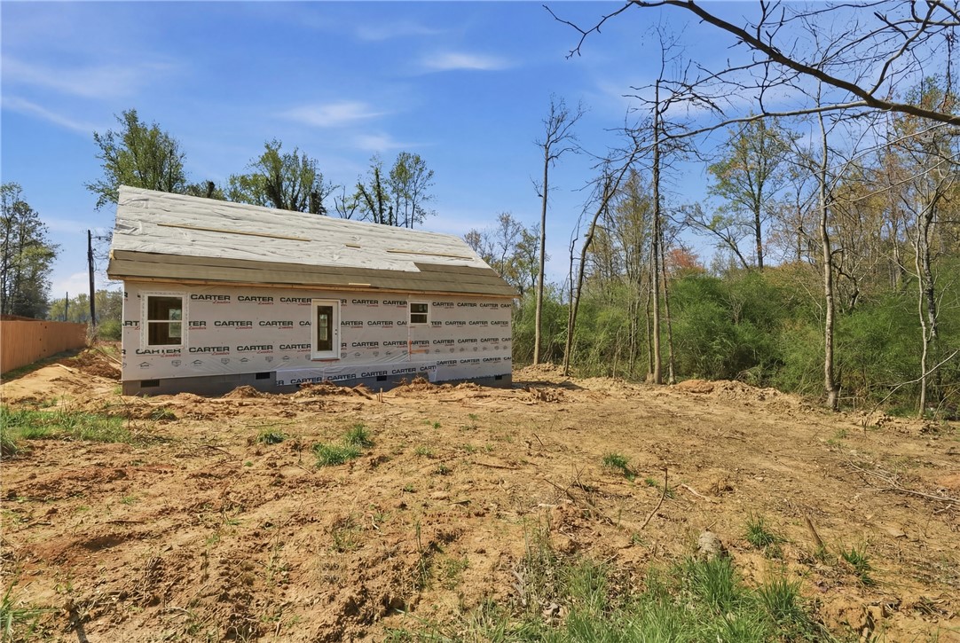 104 Albert Drive Honea Path, SC 29654 - Photo 19 of 32 A newly framed residence awaits finishing touches amidst a natural landscape, offering future comfort.