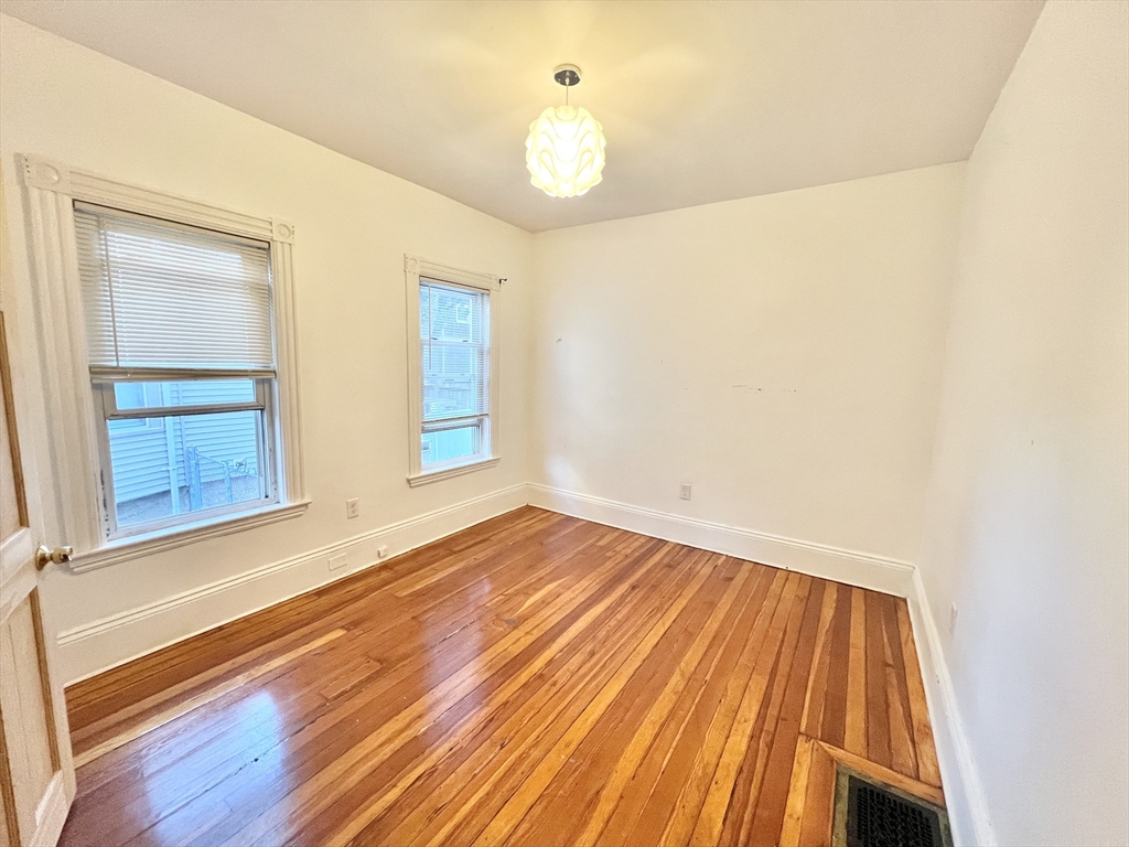 18 Sherman Street, Unit 1 Everett, MA 02149 - Photo 5 of 11 a view of an empty room with wooden floor and a window
