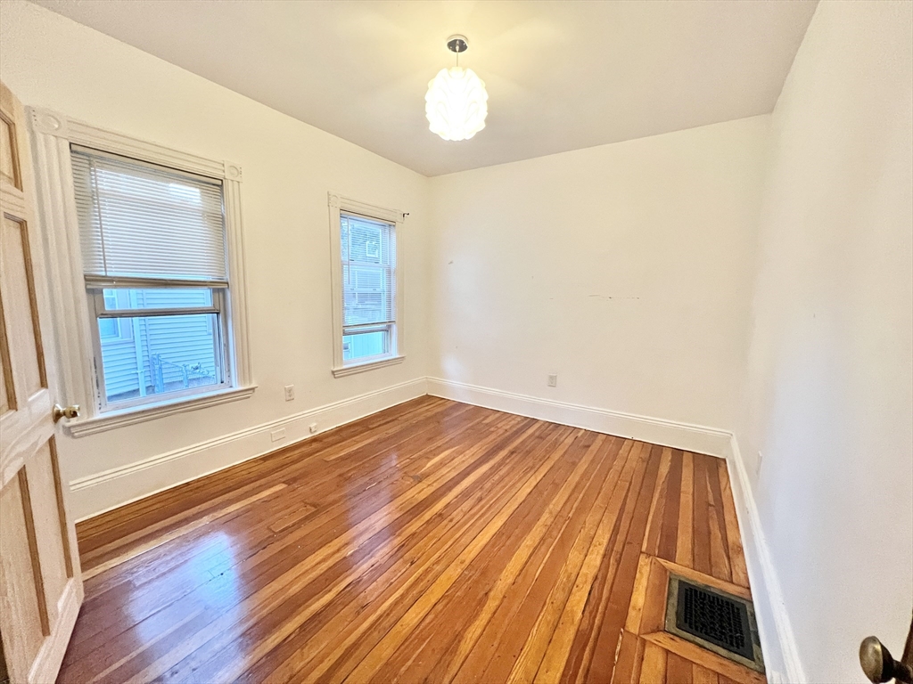 18 Sherman Street, Unit 1 Everett, MA 02149 - Photo 8 of 11 a view of an empty room with wooden floor and a window