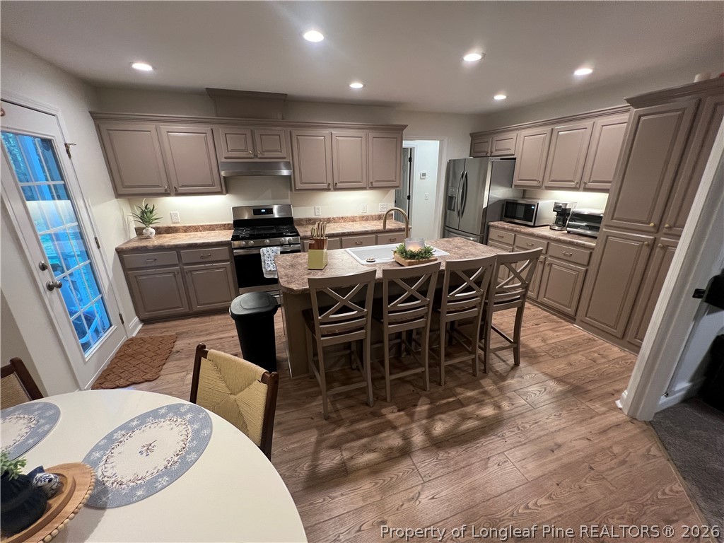 169 Bradshaw Road Bladenboro, NC 28320 - Photo 11 of 34 a kitchen with stainless steel appliances kitchen island granite countertop a sink a stove a dining table and chairs