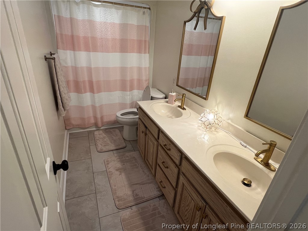 169 Bradshaw Road Bladenboro, NC 28320 - Photo 22 of 34 a bathroom with a double vanity sink toilet and shower