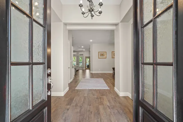 a view of a hallway with wooden floor and staircase