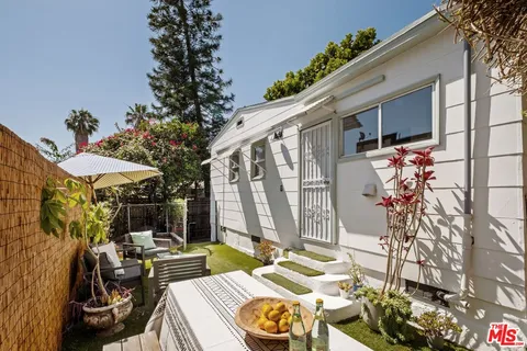 a backyard of a house with table and chairs