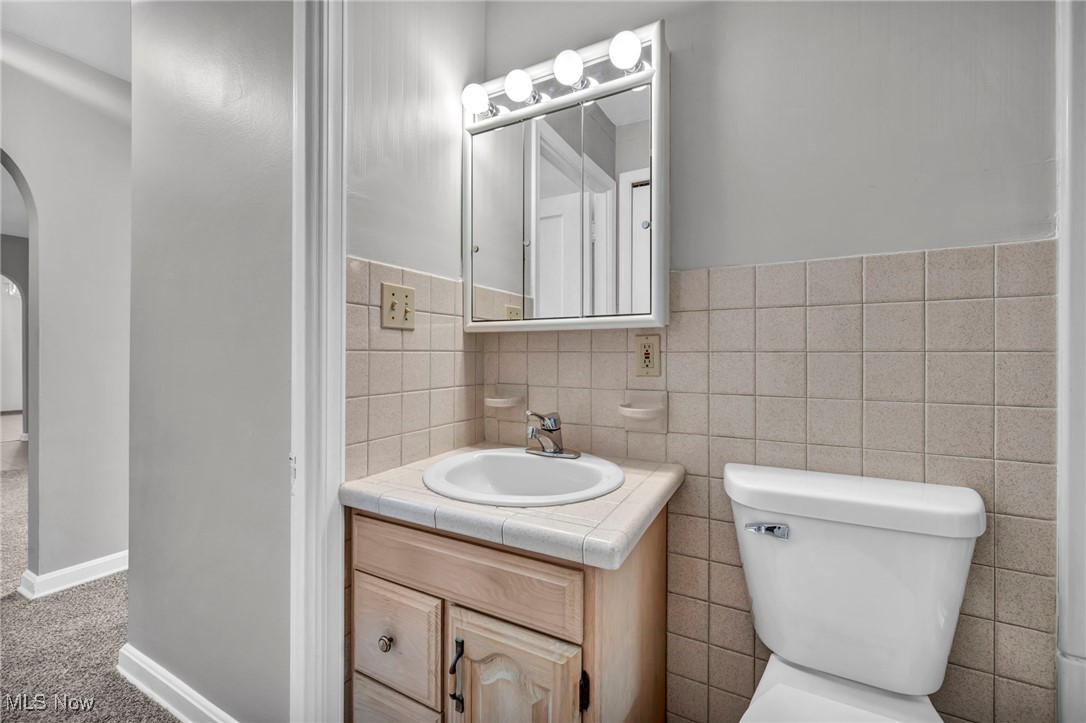 503 Churchill Road Youngstown, OH 44505 - Photo 14 of 32 Half bathroom with vanity, tile walls, and carpet