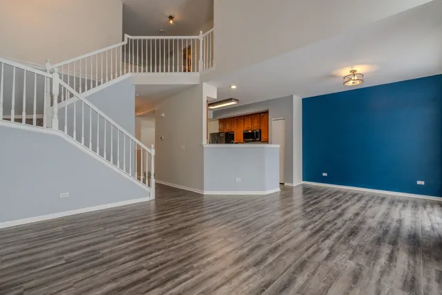 a view of a hallway with wooden floor and a kitchen