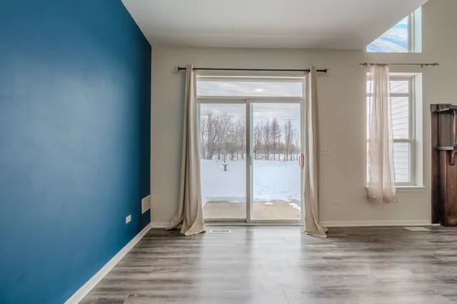 a view of a room with wooden floor and a window