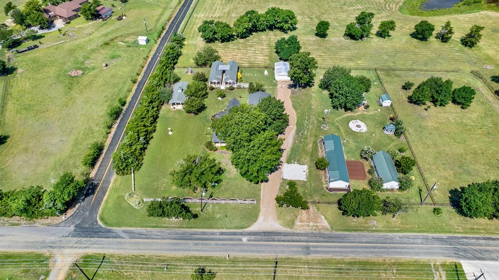1425 Lone Star Road Celina, TX 75009 - Photo 37 of 40 Perfectly positioned on a spacious corner lot, this unique estate enjoys an impressive presence with mature trees, white fencing, and beautifully maintained grounds. Surrounded by newer luxury homes on acreage, the property offers the charm of country living while blending seamlessly into one of the area's most desirable rural neighborhoods.