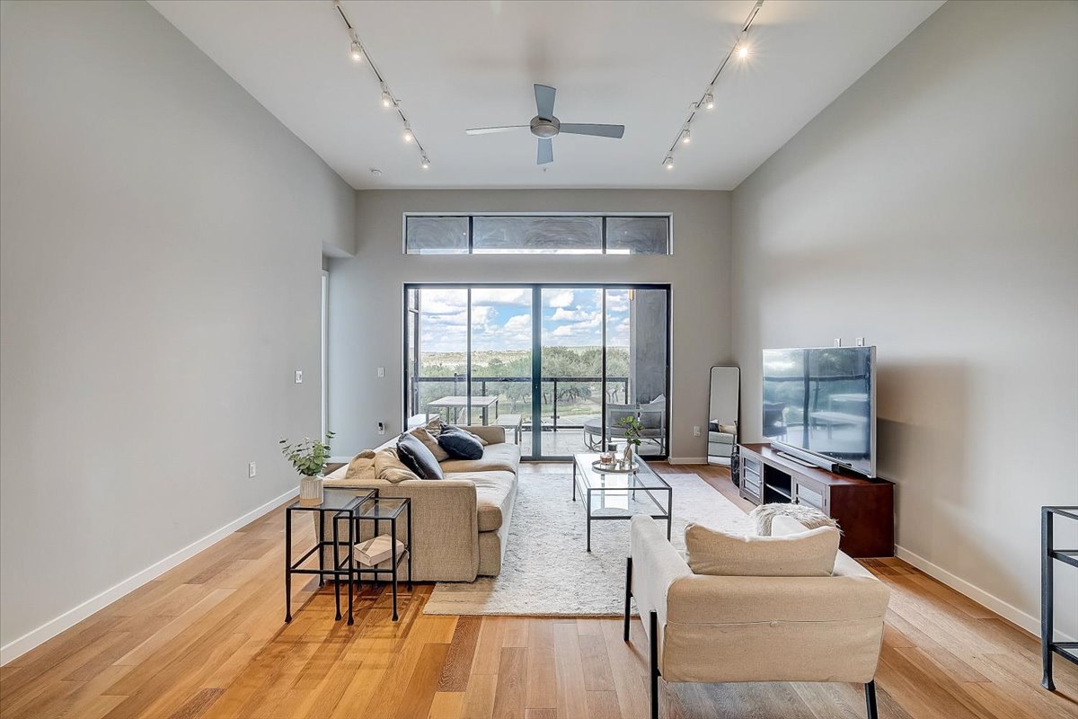 5921 Hiline Road, Unit 1204 Austin, TX 78734 - Photo 9 of 36 Living room with a high ceiling, light wood finished floors, a ceiling fan, and rail lighting