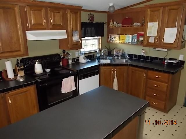 548 Rome Road Riddleton, TN 37151 - Photo 13 of 20 a kitchen with granite countertop a sink stove and cabinets