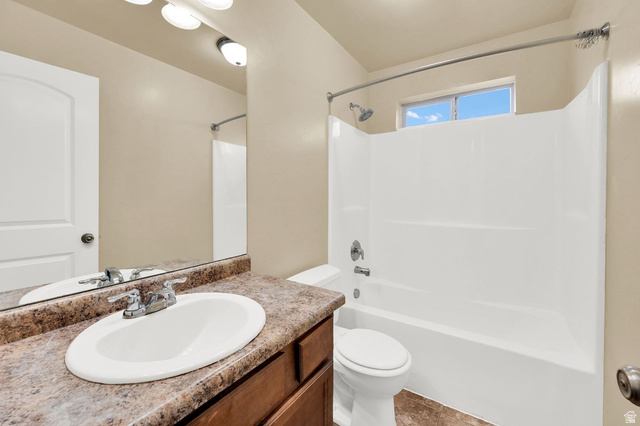 1179 West 100 South Springville, UT 84663 - Photo 15 of 32 Bathroom featuring a wood-finish vanity with an oval sink and chrome faucet, a large vanity mirror, a combination tub and shower with white surround, and an upper window providing natural light