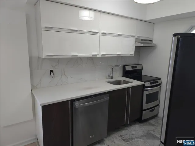 a kitchen with stainless steel appliances a sink and cabinets