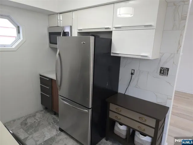a kitchen with stainless steel appliances a refrigerator and microwave