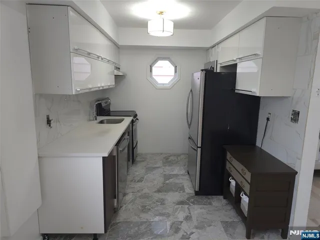 a kitchen with stainless steel appliances a refrigerator a sink a stove and cabinets