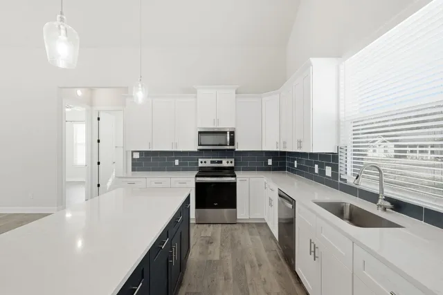 a kitchen with a sink a counter top space stainless steel appliances and cabinets