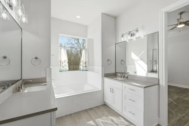 a bathroom with a granite countertop sink mirror and a bath tub