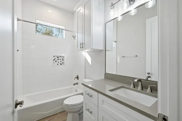 a bathroom with a granite countertop sink a toilet and a bathtub