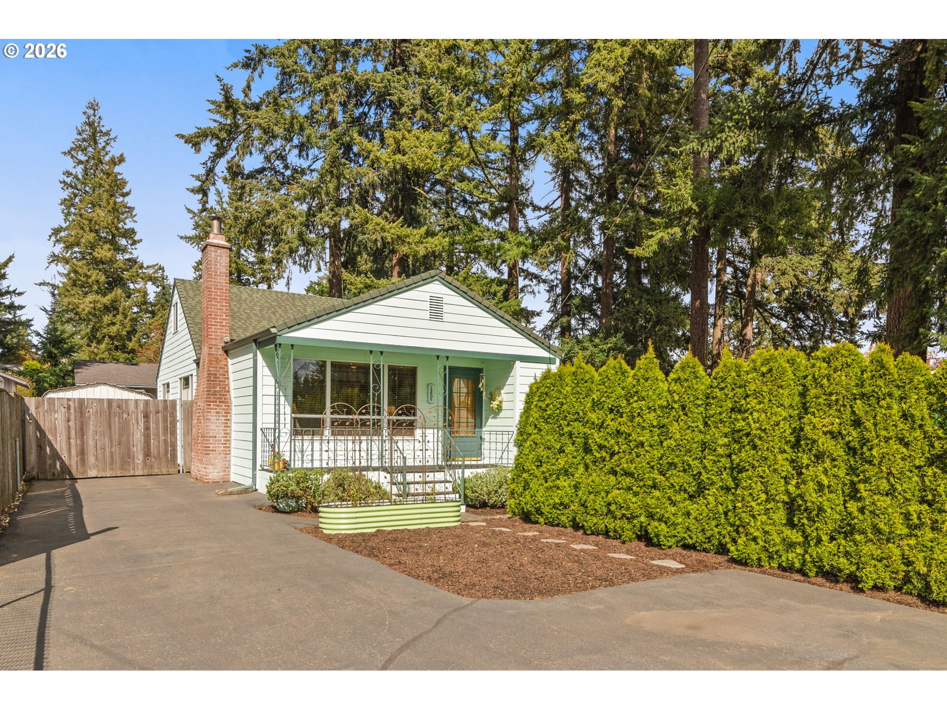 12605 Southeast Holgate Boulevard Portland, OR 97236 - Photo 2 of 43 a front view of a house with a garden