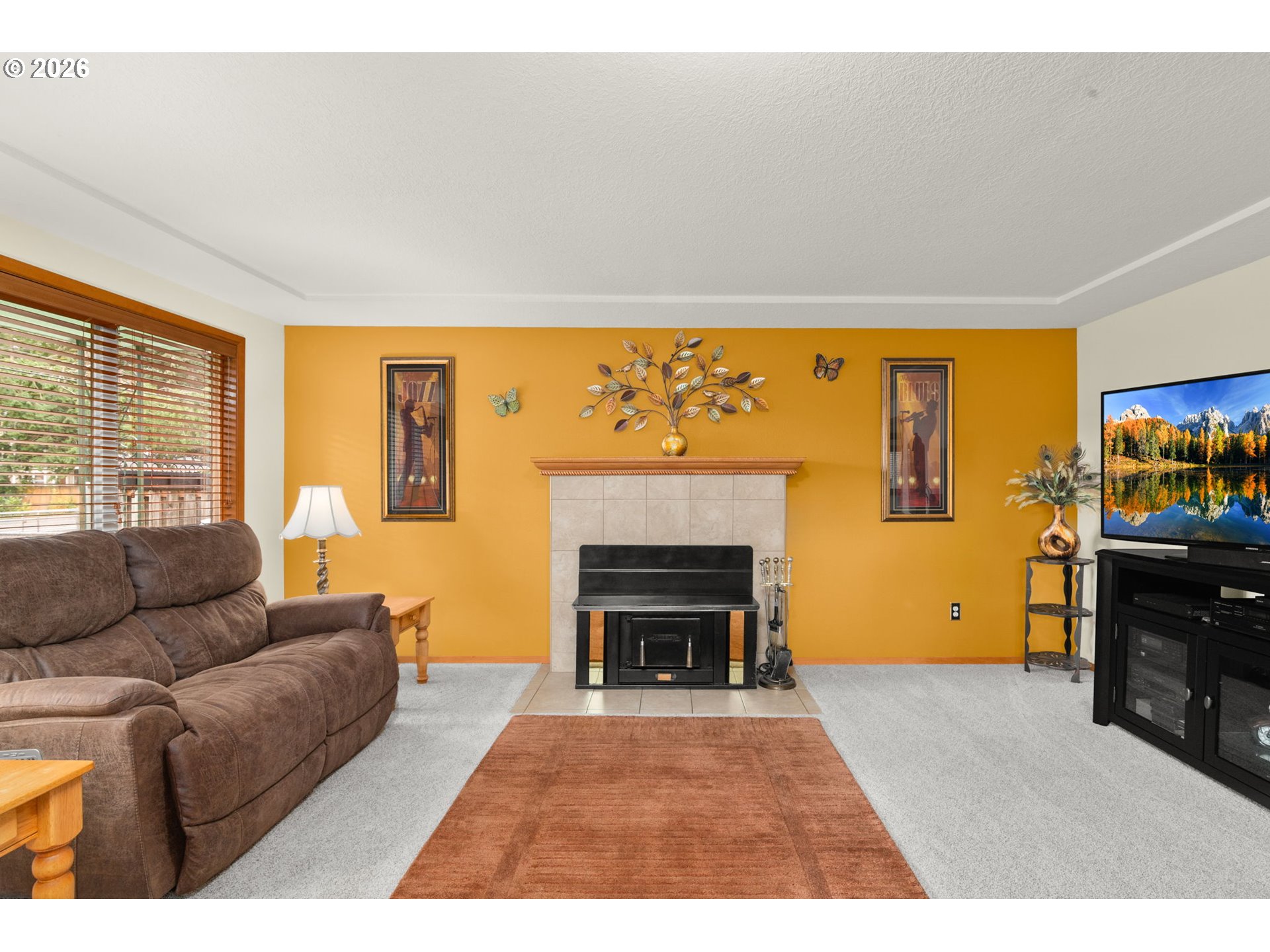12605 Southeast Holgate Boulevard Portland, OR 97236 - Photo 9 of 43 a living room with furniture a fireplace and a flat screen tv