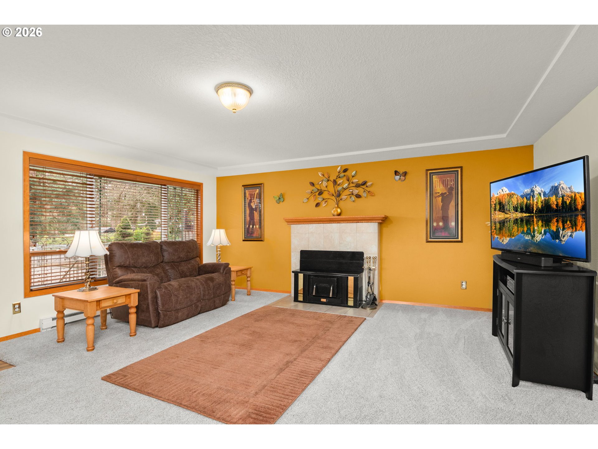 12605 Southeast Holgate Boulevard Portland, OR 97236 - Photo 10 of 43 a living room with furniture a fireplace and a flat screen tv