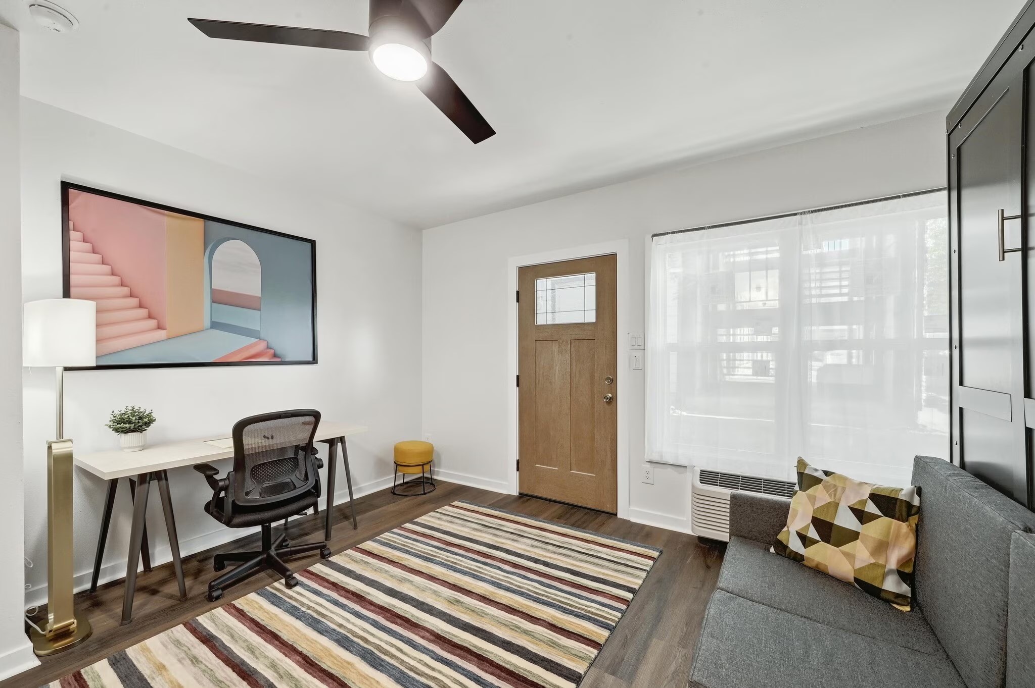 2802 Whitis Avenue, Unit 106 Austin, TX 78705 - Photo 3 of 8 Entryway featuring wood-finish flooring, a contemporary ceiling fan, and a wood entry door with frosted glass detailing