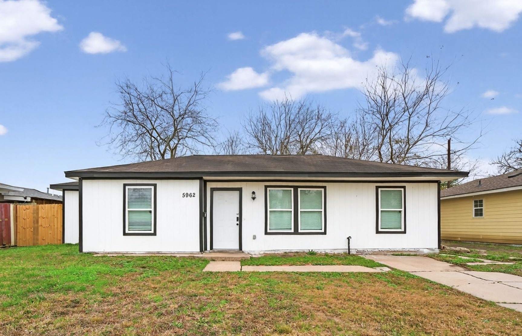 a view of a yard in front of a house with large trees