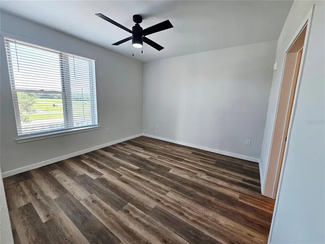 a view of a room with a ceiling fan and a window