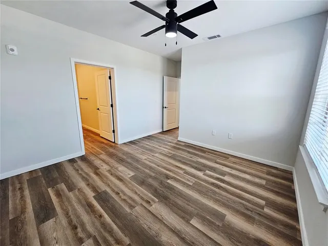a view of a livingroom with wooden floor and a ceiling fan