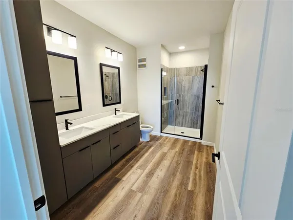 a bathroom with a double vanity sink mirror and bathtub